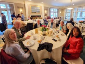 A group of smiling guests enjoying dinner at the Annual Golden Lotus Banquet, showcasing the community spirit of Song of the Morning.
